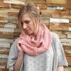 A lady standing outdoors wearing a French Rose Pink Branberry Wool Infinity Scarf