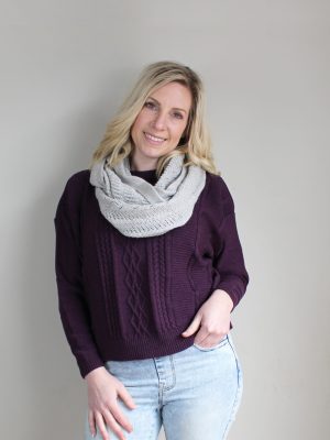A lady standing indoors wearing a Smoke Light Grey Branberry Wool Infinity Scarf