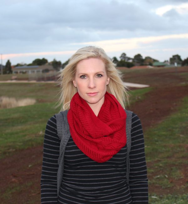 A lady standing outdoors wearing a Red Branberry Wool Infinity Scarf