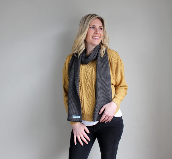 A Lady standing indoors wearing a Branberry Australian Made wool mini stripe scarf in Mocha