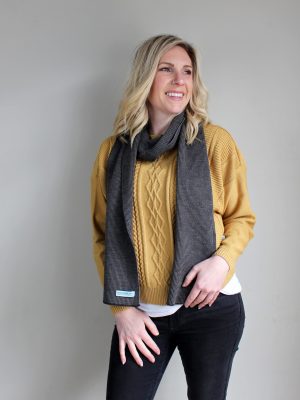 A Lady standing indoors wearing a Branberry Australian Made wool mini stripe scarf in Mocha