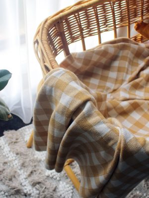 Mustard and White Gingham Blanket made from Pure Australian Merino Wool. Placed in a gorgeous bassinet with star cushion in a nursery, offering warmth and style.