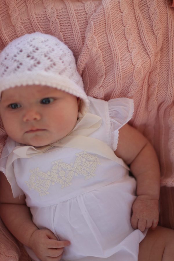 A baby laying on an Branberry Australian Made, Cotton and Merino wool blend Cable Blanket in Pale Pink