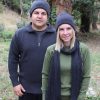A lady and man stading outside in the bush wearing Interknit Branberry branded Australian made pure merino wool beanies