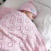 Branberry Heirloom Blanket in Pink Silk, a baby peacefully sleeping in a cot with the blanket and matching Pure Wool Frankie Beanie