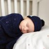 Branberry Heirloom Blanket in Princeton, a baby peacefully sleeping while swaddled in the blanket and wearing a matching Pure Wool Frankie Beanie.