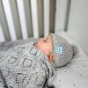 Branberry Heirloom Blanket in Smoke, a baby peacefully sleeping while swaddled in the blanket and wearing a matching Pure Wool Frankie Beanie.