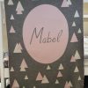 A Personalised Name Blanket with sporadic triangles with a big circle in the centre with a custom name, in a grey, pink and white colour combo, product photo. Made from Pure Australian Merino Wool and Made in Australia.
