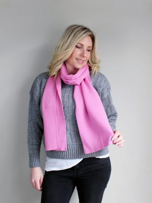 A lady wearing an Australian Made, Plain Adult Unisex Scarf in Taffy Pink, made from Pure Australian Merino Wool