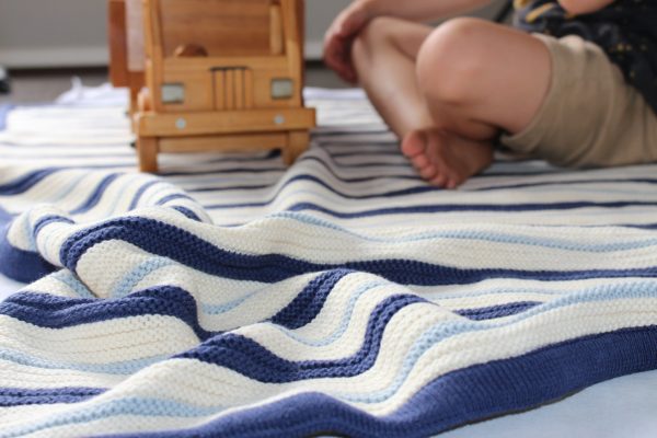Boy playing with dump truck on Navy, Blue & White Striped Garter Stitch Blanket